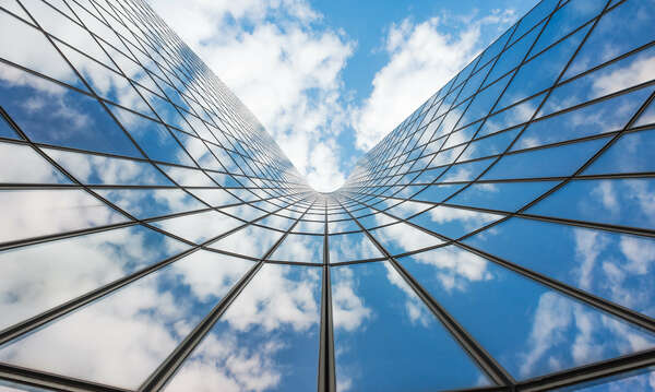 Blue sky and white clouds reflecting in a glass building