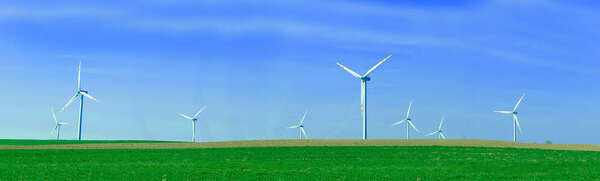 Panorama of the wind turbnes on a summer field