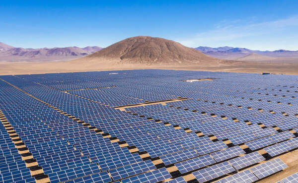 Aerial view of hundreds solar energy modules or panels rows along the dry lands at Atacama Desert, Chile. Huge Photovoltaic PV Plant in the middle of the desert from an aerial drone point of view