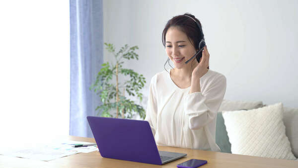 woman working from home with computer and headphones