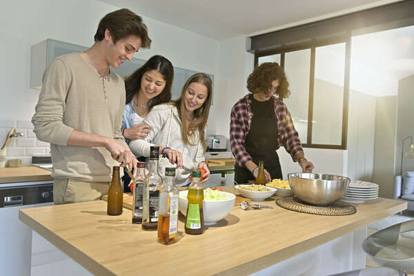 Flatmates enjoying cooking together at home