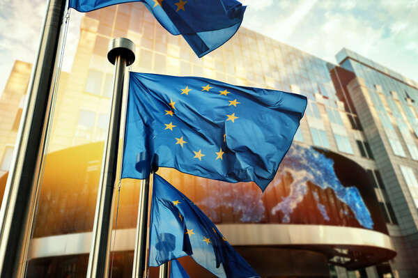 EU flags waving in front of European Parliament building. Brussels, Belgium