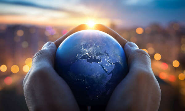 The globe Earth in the hands of man against the night city. 