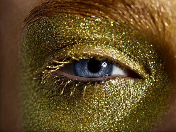 Close up of a woman with gold eye make up