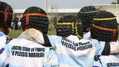 5 rugbymen together seen from the back